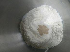 除黄油以外的所有材料按照下层液体上层粉类放入厨师机启动揉面程序。揉到面团光滑加入软化的黄油，揉到能拉出大片的膜