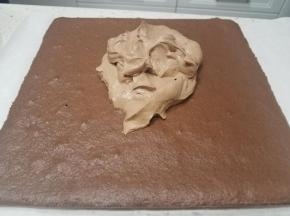 糕片冷却后脱模，转移到油纸上，把准备好的夹馅奶油倒入。