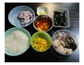 海鮮洗净，虾剪须、鱿魚煎圈、带子剪掉边；黄椒、洋蔥、西红柿切成丁、蒜切末；米用水浸泡20分钟、藏红花和咖喱块分別用开水泡开备用