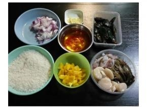 海鮮洗净，虾剪须、鱿魚煎圈、带子剪掉边；黄椒、洋蔥、西红柿切成丁、蒜切末；米用水浸泡20分钟、藏红花和咖喱块分別用开水泡开备用