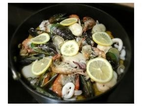 最后将海鮮全部倒入锅里，如果你喜欢码放整齐的样子也可以不把海鲜和米饭拌匀哒，放上柠檬片后盖上锅盖焖五分钟。

