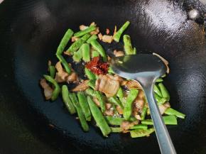 豆角炒七成熟，放豆瓣酱炒出红油，放一勺料酒。