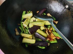 把茄子腌出来的水倒掉，放入锅内，翻炒。