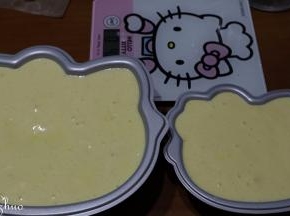 倒入KITTY蛋糕模具中，放抹布上轻振去大气泡。模具无需铺油纸。