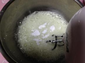低速打发蛋白至粗泡，加三分之一糖继续打发
