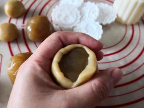 6.	把面团先按扁再慢慢用虎口往上推，包住莲蓉馅，