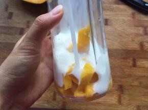 现在做芒果慕斯液，将芒果和酸奶混合，放入料理机中打成糊状，加入泡软的吉利丁片，隔热水融化