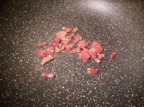 锅里加适量的油，倒腊肠丁翻炒，炒至透明状就可以了