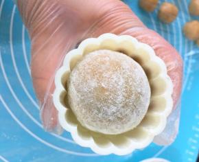 把月饼生坯涂一层薄薄的手粉，装入模具中