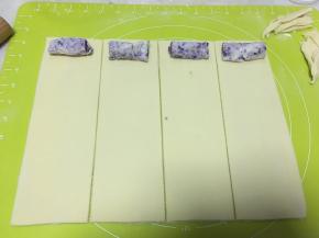 冰箱取出冷冻的紫薯馅，分切成4等份，摆在4分面片的一头