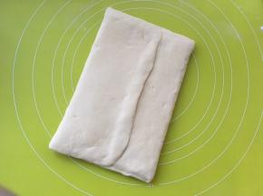 将两侧面片对折，包裹上黄油片，捏紧收口