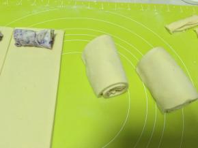 之后取一份裁掉的边角，平铺在馅外层，一起卷起来