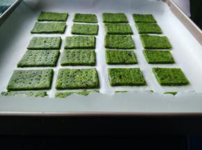 将面团擀成4毫米的面片，放在油纸上，再把面片切割成大小合适的方形，均匀排放，连同油纸一起移入烤盘。
