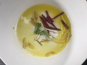 热锅烧油，放入姜丝爆香后加入干辣椒和葱段爆香