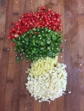 青尖椒和红尖椒切成圈，蒜瓣剁成蒜蓉，生姜削皮切成末备用。