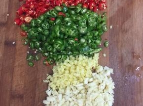 青尖椒和红尖椒切成圈，蒜瓣剁成蒜蓉，生姜削皮切成末备用。