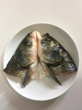 把腌制好的鱼头放在姜片上。