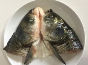 把腌制好的鱼头放在姜片上。