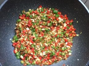 锅烧热倒入适量的油，放入蒜蓉，姜末，青红尖椒圈翻炒均匀。