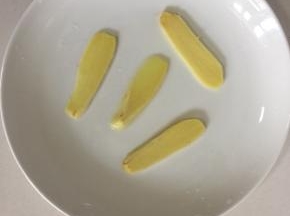 生姜切成片摆在盘子底部。（盘子底部放姜片不仅可以防止鱼头粘在盘子底部，还能起到去腥的作用呢！）
