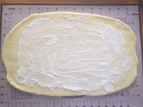 拿出排气，松弛15分钟，用擀面棒擀成长方形，抹上沙拉酱