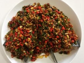 把炒好的剁椒均匀的铺在鱼头上。
