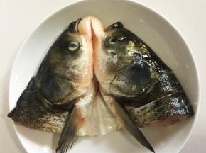 鱼头处理干净，对半剖开，有鱼肉的地方斜切几刀，加入一勺盐和适量的料酒涂抹均匀腌制15分钟。
