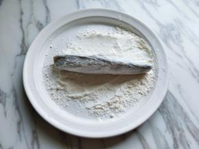 取一块大一点的盘子，放上上午面粉，将腌制好的冰鱼段，放入面粉中，裹上面粉，最后在抖掉多余的面粉。