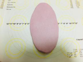 松弛好的面团，轻拍按扁，擀成牛舌型。排掉边缘处的气泡。（紫薯粉7克的效果，颜色增减看个人喜好）