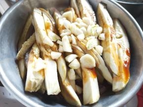 将蒸好的茄子淋上麻油、香醋、酱油、胡椒粉、蒜，再浇上刚做的辣子