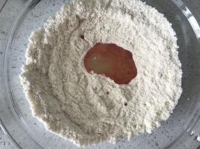 把蛋清1倒入杏仁粉里面，用刮刀搅拌均匀，这个不用注意手法，拌匀即可，拌好的状态是不粘刮刀的。