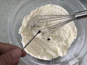 加入三小勺粉紫色色粉，用手动打蛋器搅拌均匀，这个勺子是色粉专用勺，买DR色粉时配带的，大家如果没有DR色粉，用色膏也可以，我用过惠尔通的色膏做过也可以，用色膏的话，把色膏放到蛋清里搅拌均匀再倒入杏仁粉里拌匀就行了，但千万别用液体色素，有水份，会失败。