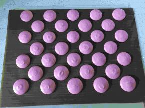 接下来挤马卡龙，裱花嘴垂直烤盘挤出合适的大小，在收尾时迅速画一个逗号，这样不会留下小尖尖，挤好后轻轻震几次盘，震出大气泡。