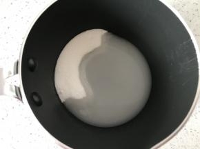 把细砂糖2倒入奶锅中，加入矿泉水1，奶锅大家尽量选择口径小的，我这个是12厘米口径的，不要选择12厘米以上的，太大口径的熬糖水容易糊底。