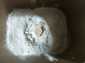 面包机先放入牛奶和鸡蛋，对角放盐和糖，再放入高筋面粉，中间挖个洞放入酵母。启动揉面程序15分钟。