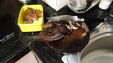 煮过的熏肉捞起冲洗干净表面的黑色物，切片备用