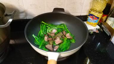 菜心变软后再倒入熏肉