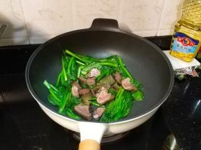 菜心变软后再倒入熏肉