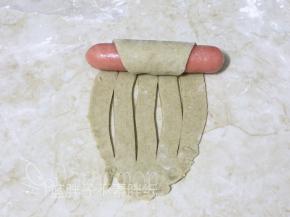 面团顶端摆上1根香肠， 连同香肠由上往下卷起来。