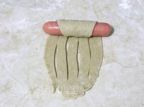 面团顶端摆上1根香肠， 连同香肠由上往下卷起来。