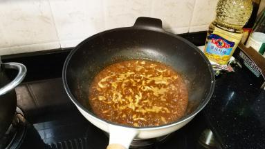倒入水、白酒（料酒）、老抽、糖煮制至熟盛起