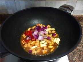 放入泡椒、泡姜、大蒜和洋葱翻炒10秒。