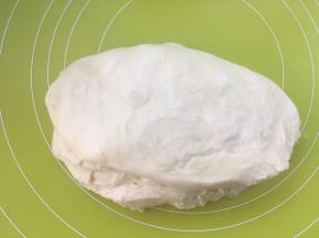 将面团取出，放揉面垫上按压排气