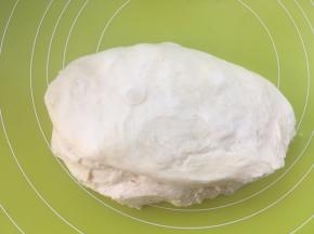 将面团取出，放揉面垫上按压排气