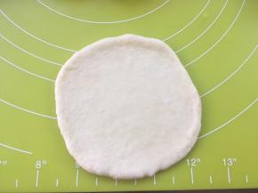 取一份松弛好的面团，用擀面杖擀成圆片