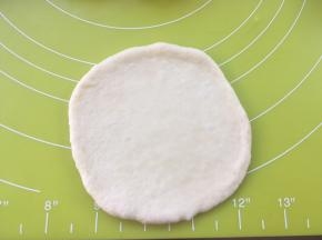 取一份松弛好的面团，用擀面杖擀成圆片