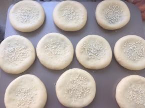 烤箱预热180度，表面撒点白芝麻，之后用手压一下白芝麻