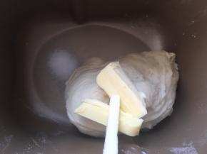 加入盐跟软化的黄油，继续启动揉面程序，将黄油，盐跟面团揉均匀