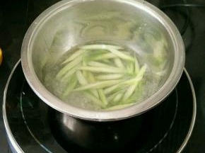 不锈钢盆里放入适量水，加入一点盐和油烧开，下芦笋焯水十几秒钟捞出。