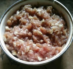 猪肉剁碎，加入蒜蓉、耗油、生抽、料酒、盐和淀粉，搅拌均匀后腌半个小时左右。